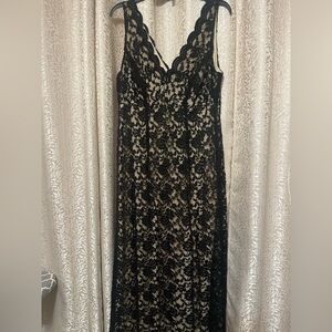 Black lace dress with nude undertone.
Scalloped neckline.